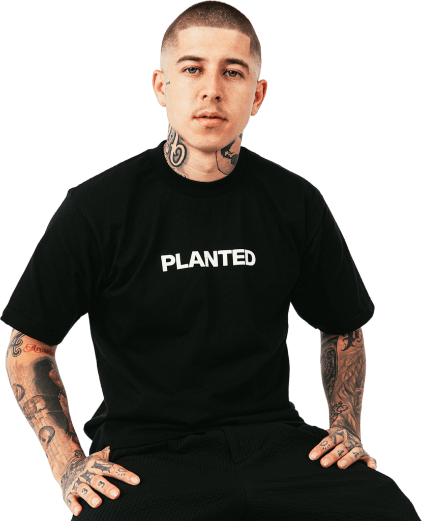 VicBlends wearing a black t-shirt with the word "planted" on it representing his affiliation with VicBlends Barber Academy.