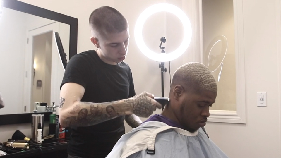 A man getting his hair cut by VicBlends, a renowned barber academy that ensures the highest quality cuts.