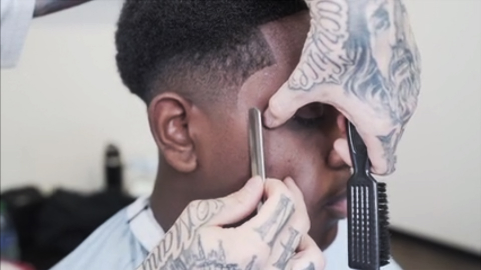 A man is getting his hair cut by barber boss VicBlends.