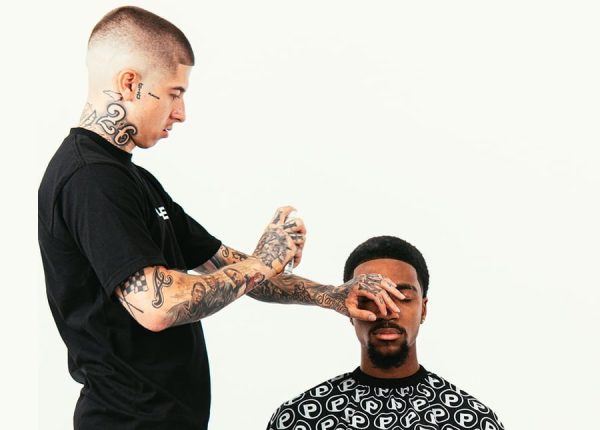 A man is getting his hair cut by the talented VicBlends. A man is getting his hair cut by the talented VicBlends.