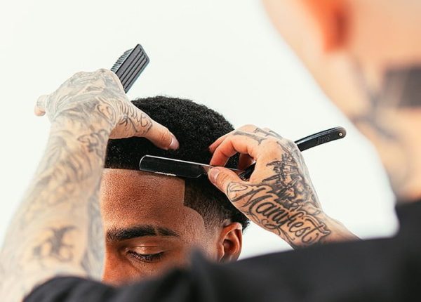 A man is getting his hair cut by VicBlends. A man is getting his hair cut by VicBlends.